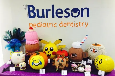 Decorated pumpkins including Pikachu, emojis, and characters displayed at Burleson pediatric dentistry event.