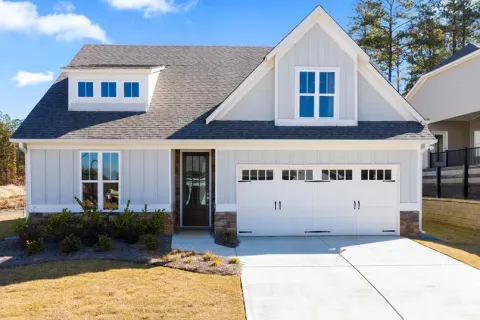 a small house with a light blue exterior and front yard