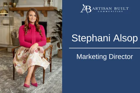 Marketing Director Stephani Alsop seated in a cozy modern living room, wearing a pink blouse and floral skirt.
