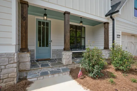a house with a stone patio and a green door