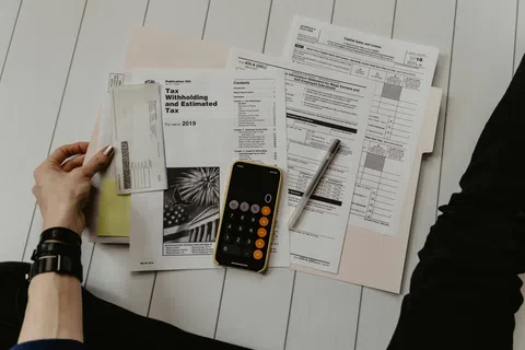 a person holding a phone and a newspaper