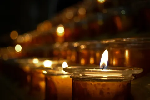 Close-up of glowing candles in glass holders creating a warm, serene atmosphere with soft bokeh lights.