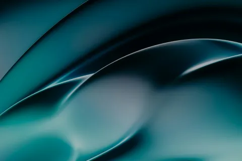 Smooth abstract blue and green curved shapes with soft gradients and reflections creating a futuristic look.