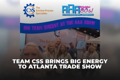 Team CSS members smiling at Atlanta trade show with banners for Eviction Process Specialists and AAA show.