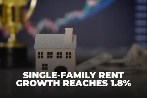 Miniature house model with blurred financial chart and trophy in background, highlighting rent growth news.