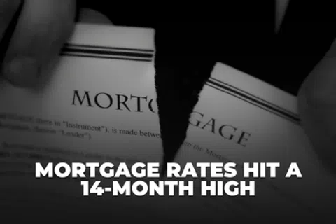 Close-up of torn mortgage document with text announcing mortgage rates hit a 14-month high.