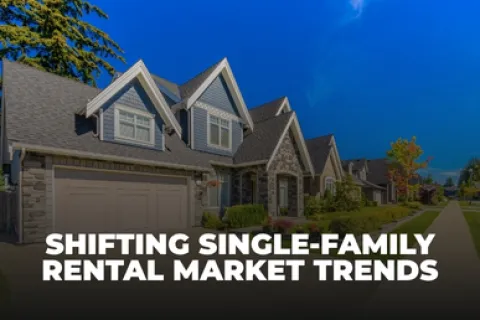 Modern single-family homes in a suburban neighborhood with clear skies and green lawns.