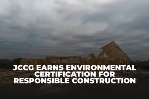 Construction site with wooden framing under cloudy sky and text about environmental certification for responsible building.