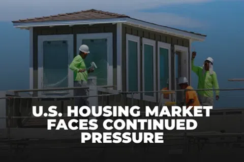 Construction workers painting a house exterior under the headline about continued pressure on the U.S. housing market