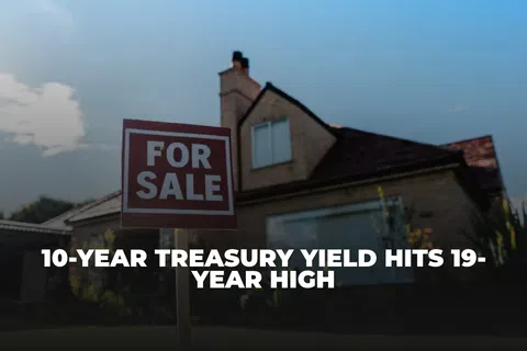 House with a For Sale sign in front under a clear blue sky, highlighting real estate market activity.