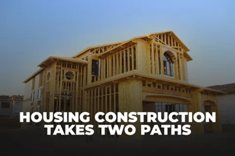 Wood-framed house under construction with text Housing Construction Takes Two Paths overlayed on the image