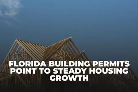 Wooden house frames under construction with text about Florida building permits and housing growth against a blue sky.