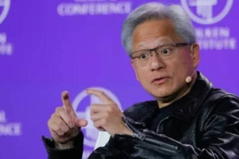 Speaker in black leather jacket and glasses gestures during a tech conference with purple branded background