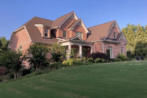 a large brick house with a lawn in front of it