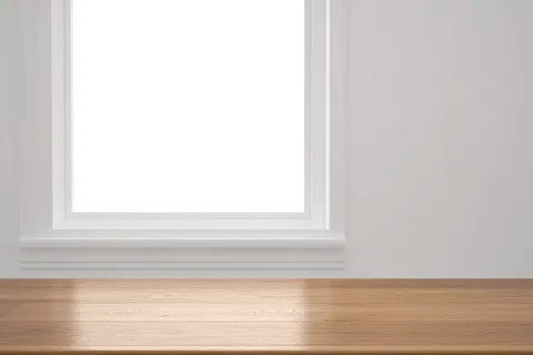 Empty wooden table with sunlight near a white window in a bright minimal room.
