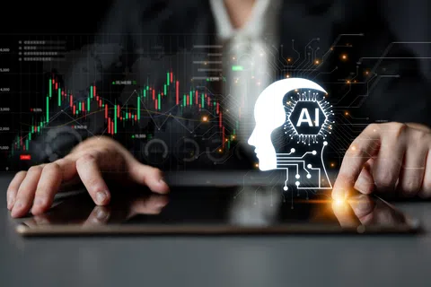 Businessperson interacting with tablet displaying AI head icon and stock market charts in the background.
