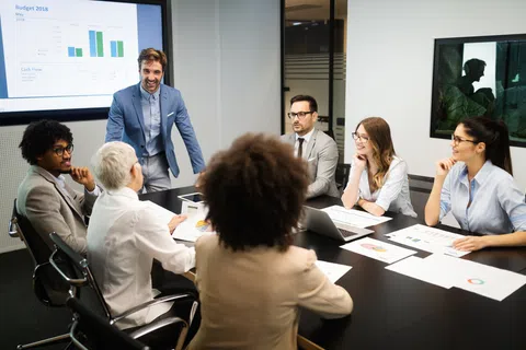 Business team in a meeting discussing financial charts and data in a modern office conference room.