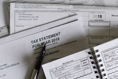 2019 tax statement with pen and mileage logbook on table for tax preparation and filing