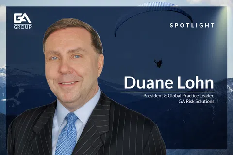 Portrait of Duane Lohn, President & Global Practice Leader of GA Risk Solutions, with mountain and paraglider background
