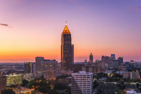 Atlanta skyline at sunset with tall illuminated skyscraper and colorful evening sky
