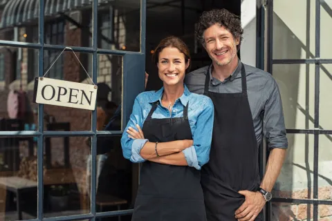a man and a woman standing in front of a gate