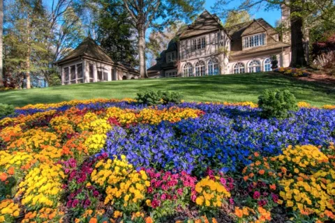 a colorful flower garden in front of a house