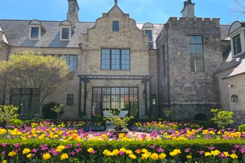 a large stone building with many windows and flowers in front of it
