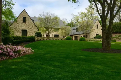 a large green field in front of a house
