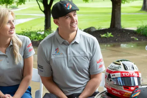Courtney Force, Graham Rahal riding on the back of a motorcycle