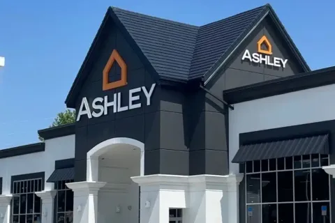 Modern Ashley Furniture store exterior with black and white design under clear blue sky
