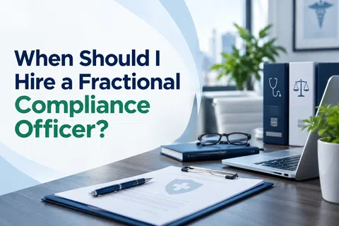 Office desk with documents, laptop, medical binders, and text about hiring a fractional compliance officer.