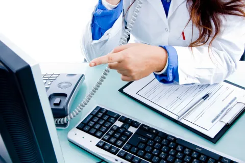 a person sitting at a desk with a laptop computer