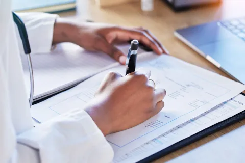 a person writing on a piece of paper