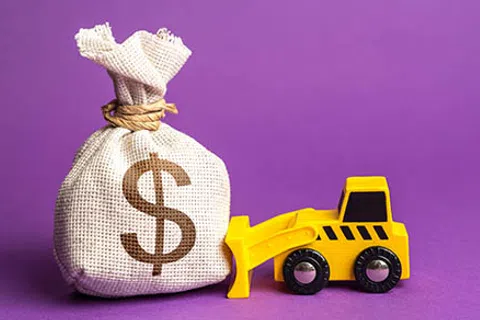 Yellow toy bulldozer pushing a burlap sack with a dollar sign on a purple background