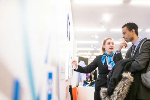 a man and a woman looking at a whiteboard