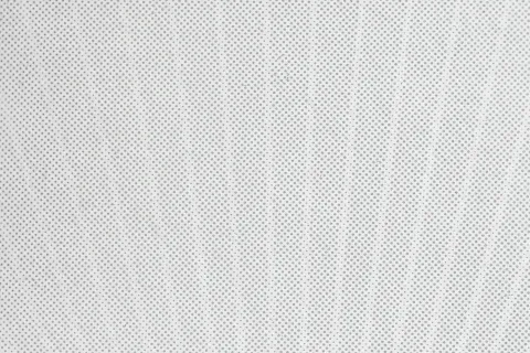 Close-up of a white textured surface with a pattern of evenly spaced small holes or dots.