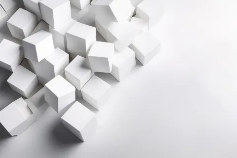 Cluster of white 3D cubes on a white surface with soft shadows creating a modern abstract composition