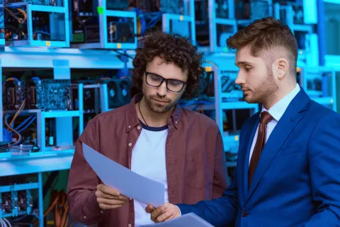 a couple of men looking at a sheet of paper