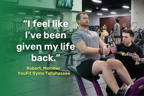Man exercising on rowing machine with trainer assisting in a busy gym setting with motivational quote overlay.