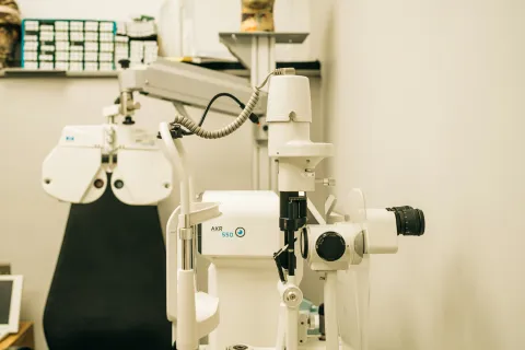Close-up of a slit lamp biomicroscope and eye exam equipment in an optometrist's office.