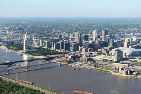 Aerial view of St. Louis city skyline with Gateway Arch, bridges, and Mississippi River on a clear day