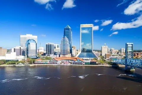 a bridge over a body of water with a city in the background