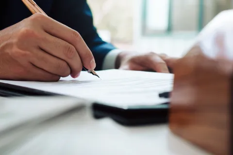 a person writing on a piece of paper
