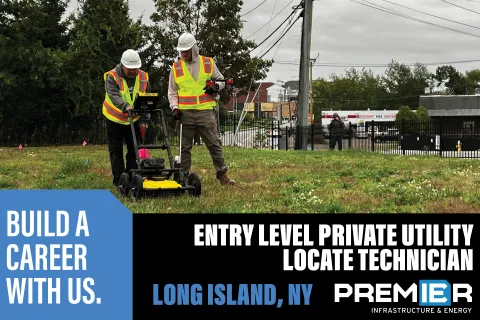 a couple of men wearing safety vests and standing next to a lawn mower