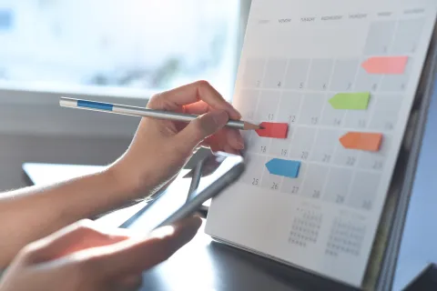 a person writing on a calendar