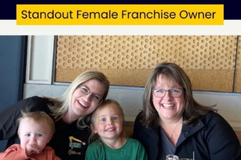 Trish Duarte with two women and two children smiling in a casual indoor setting under standout franchise owner title