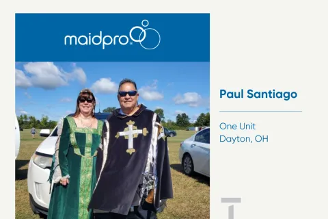 Two people in medieval costumes standing outdoors near cars under a blue sky, MaidPro franchise awarded.