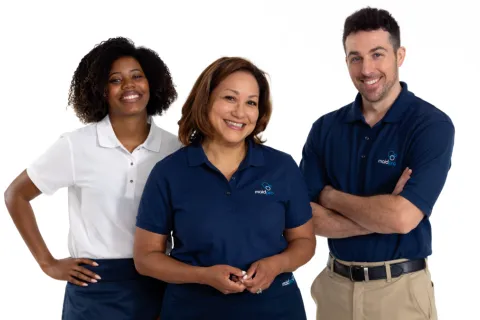 Three smiling cleaning staff wearing MaidPro uniforms standing against a white background.