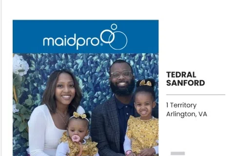 Family portrait of Tedral Sanford with wife and two daughters in front of MaidPro banner in Arlington, VA.
