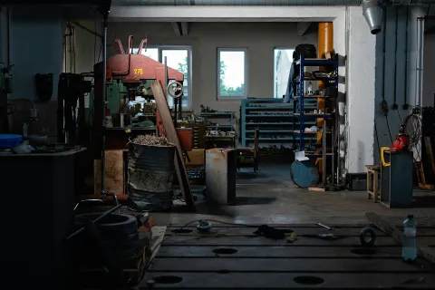 A dimly lit workshop showcasing tools, machinery, and organized storage space.